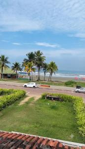 a white car driving down a road next to the beach at Cibratel Hostel - Pé na Areia in Itanhaém
