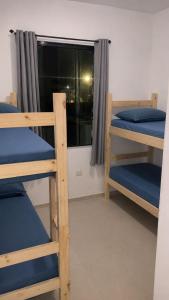 a room with three bunk beds and a window at Cibratel Hostel - Pé na Areia in Itanhaém