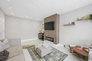 a living room with a couch and a fireplace at Spacious Modern home in the heart of Whitefield - Private Driveway Parking in Whitefield