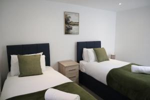 two beds sitting next to each other in a bedroom at City Centre Guest House - Gloucester Park in Gloucester