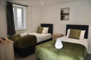 a hotel room with two beds and a window at City Centre Guest House - Gloucester Park in Gloucester