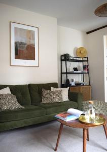 a living room with a green couch and a table at Town Centre - Elegant Stylish Apartment in Shrewsbury