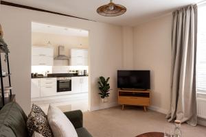 a living room with a couch and a flat screen tv at Town Centre - Elegant Stylish Apartment in Shrewsbury