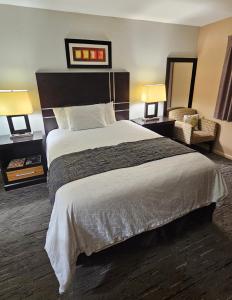 a hotel room with a large bed and two lamps at Monroe Motel Near Seattle Everett WA in Monroe