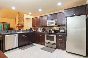 a large kitchen with wooden cabinets and white appliances at Hearthstone in Deming