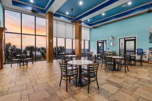 a dining room with tables and chairs and large windows at Monterey Bay Suites in Myrtle Beach +34 photos
