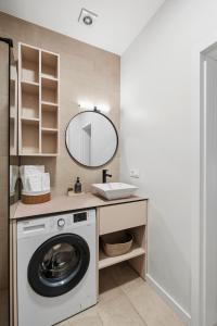 a bathroom with a washing machine and a mirror at Spacious Studio Near Station Klaipėda in Klaipėda +11 photos