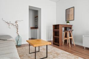 a living room with a table and a stool at Spacious Studio Near Station Klaipėda in Klaipėda