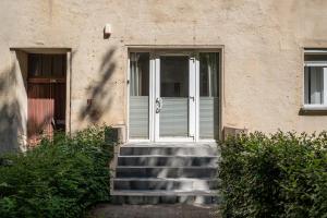 a set of stairs leading to a white door at Spacious Studio Near Station Klaipėda in Klaipėda