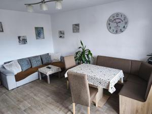 a living room with a couch and a table and a clock at Apartmán Jarka in Bodice
