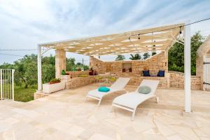 a pavilion with two chairs and a table on a patio at Masseria Carperi in Cisternino