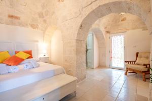 a bedroom with a large bed in a stone wall at Masseria Carperi in Cisternino +37 photos