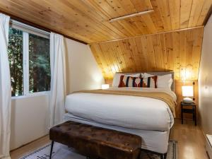 a bedroom with a bed and a wooden ceiling at Birdhouse Cottage in Glacier