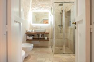 a bathroom with a shower and a toilet and a sink at Trullo Suite in Masseria in Cisternino +30 photos