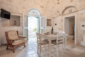 a dining room with a white table and chairs at Trullo Suite in Masseria in Cisternino
