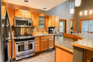 a large kitchen with wooden cabinets and stainless steel appliances at Avventura Chalet in Glacier