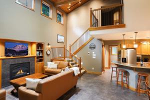 a living room with a couch and a fireplace at Avventura Chalet in Glacier +46 photos