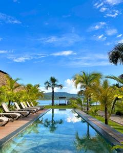 a swimming pool with lounge chairs and palm trees at El Sauce Resort in Sauce