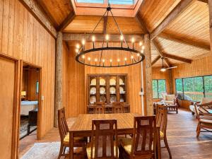 a dining room with a table and chairs and a chandelier at Tiki Treehouse in Keaau