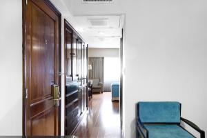 a hallway with a blue chair and a door at Cyan Hotel de Las Americas in Buenos Aires