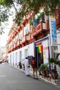 zwei Männer stehen vor einem Gebäude in der Unterkunft Hôtel Oceanic in Dakar