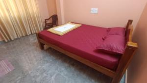 a small bed in a room with a purple blanket at Heera BEACH WAVE STAY in Gokarn