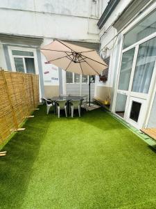 a patio with a table and chairs and an umbrella at ToledoStation B&B in Naples