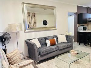 a living room with a couch and a mirror at CLASSY and COZY 3 in Fourways