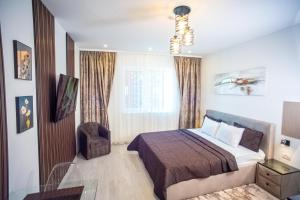 a bedroom with a bed and a chair and a window at Ariana Deluxe Suites in Bucharest +35 photos