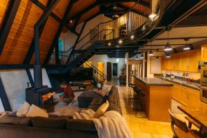 a man sitting on a couch in a living room with a fireplace at Alpine Lodge in Glacier