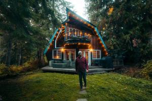 a woman standing in front of a tree house at Alpine Lodge in Glacier