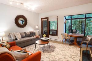 a living room with a couch and a table at Cedar Suite at Snowater in Glacier