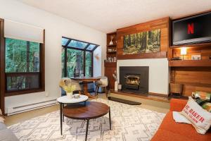 a living room with a tv and a fireplace at Cedar Suite at Snowater in Glacier