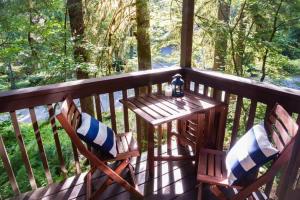 a table and chairs on a porch with a view at Cedar Suite at Snowater in Glacier