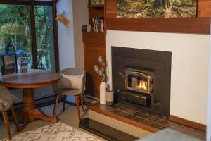 a living room with a fireplace and a table at Cedar Suite at Snowater in Glacier +23 photos