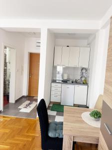 a kitchen and a dining room with a table at Banja Koviljača Apartmani Matić in Banja Koviljača