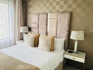 a bedroom with a large white bed with two lamps at CLASSY and COZY 3 in Fourways