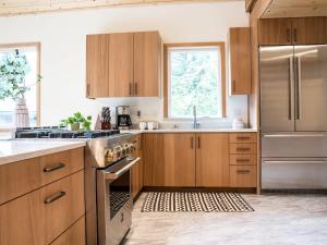 a kitchen with wooden cabinets and a stainless steel refrigerator at Church Mountain View Chalet in Glacier