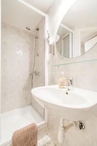 a white bathroom with a sink and a mirror at Romantic Hideaway Centertown in Budapest