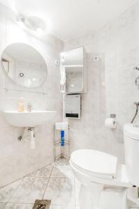 a white bathroom with a toilet and a sink at Romantic Hideaway Centertown in Budapest
