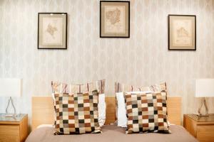 ブダペストにあるRomantic Hideaway Centertownのベッドルーム1室(枕2つ、壁に絵画付)
