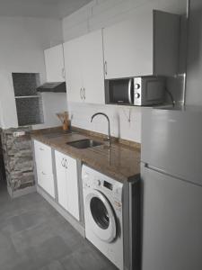 a kitchen with a sink and a washing machine at Alojamiento el Chaparro Barbate junto a la venta el loro in Barbate
