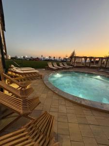a swimming pool with lounge chairs next to at Lola apartman Residence Hill in Kopaonik