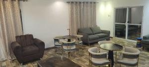 ein Wohnzimmer mit Sofa, Stühlen und Tischen in der Unterkunft HattiHome in Freetown + 3 Fotos