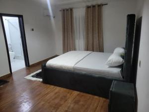 ein Schlafzimmer mit einem Bett und einem Spiegel in der Unterkunft HattiHome in Freetown