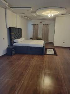 ein Schlafzimmer mit einem großen Bett und einem Holzboden in der Unterkunft HattiHome in Freetown