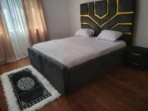 ein Schlafzimmer mit einem Bett mit einem schwarz-goldenen Kopfteil in der Unterkunft HattiHome in Freetown