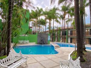 a swimming pool with a fountain in a building with palm trees at Hotel Solé Plaza Guadalajara in Guadalajara