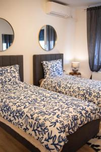 a bedroom with two beds and two mirrors at Apartman NOA in Novska