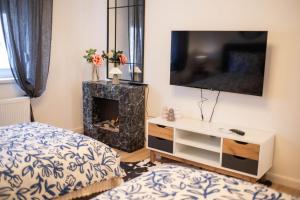 a bedroom with a bed and a tv and a fireplace at Apartman NOA in Novska